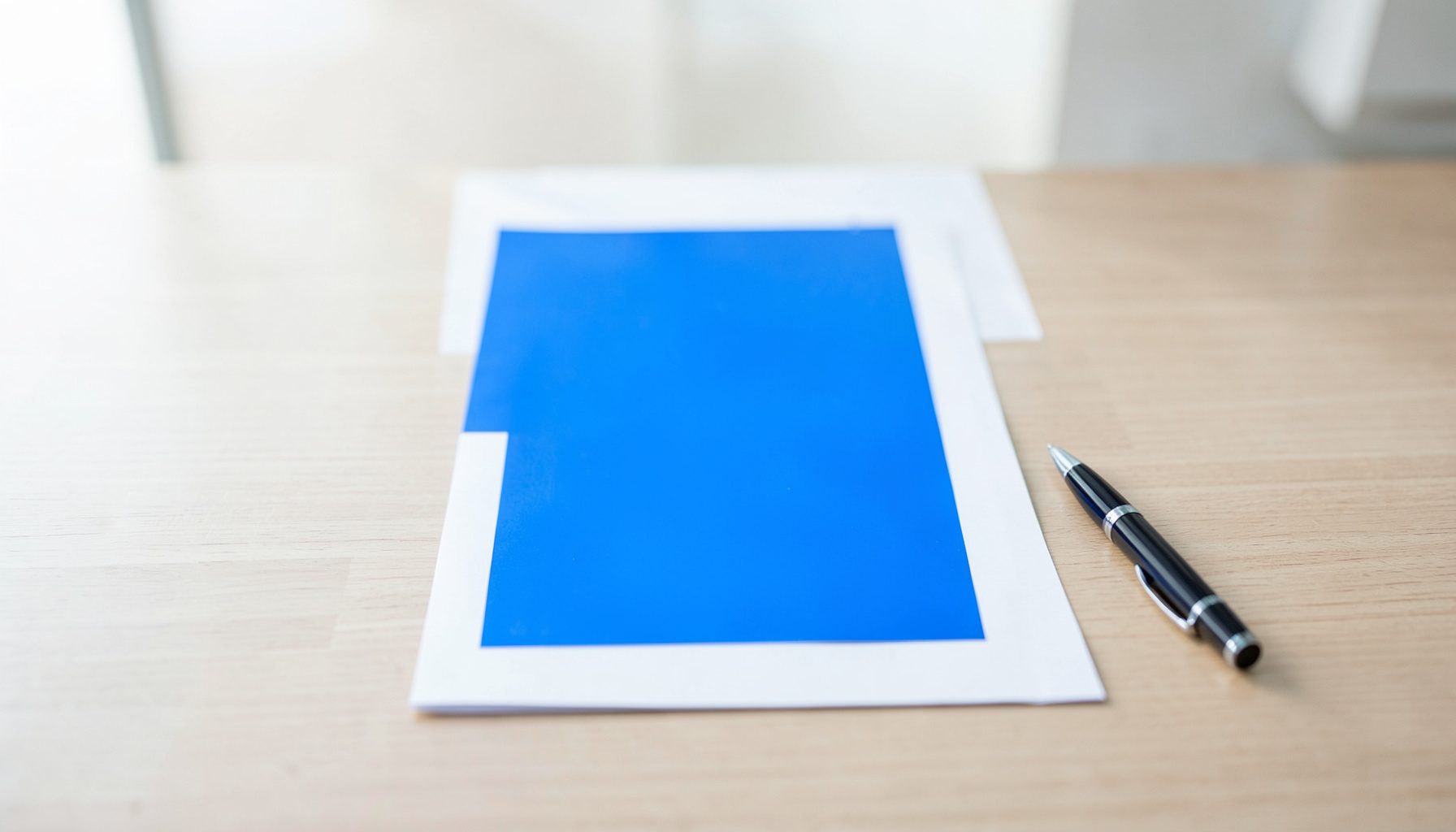 A clean architectural photograph of a certification document on a desk with a pen, soft natural light, professional and reassuring mood.